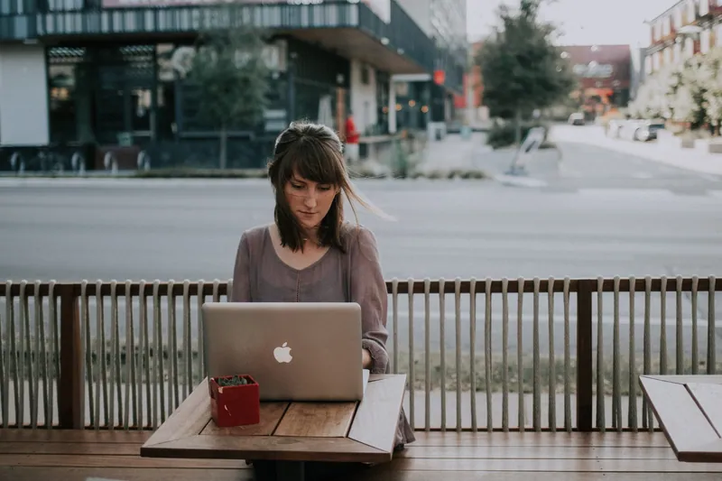 Foto de uma mulher trabalhando em um laptop tentando obter respostas de e-mail