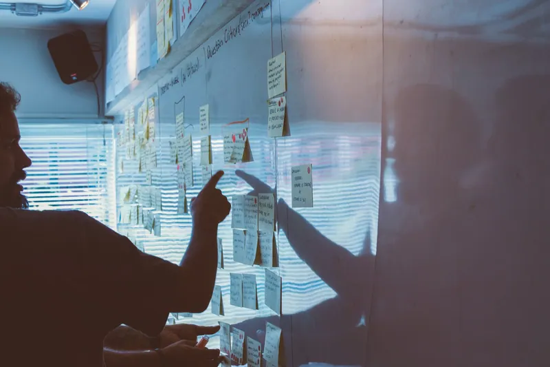 team dat samenwerkt met sticky notes op het whiteboard