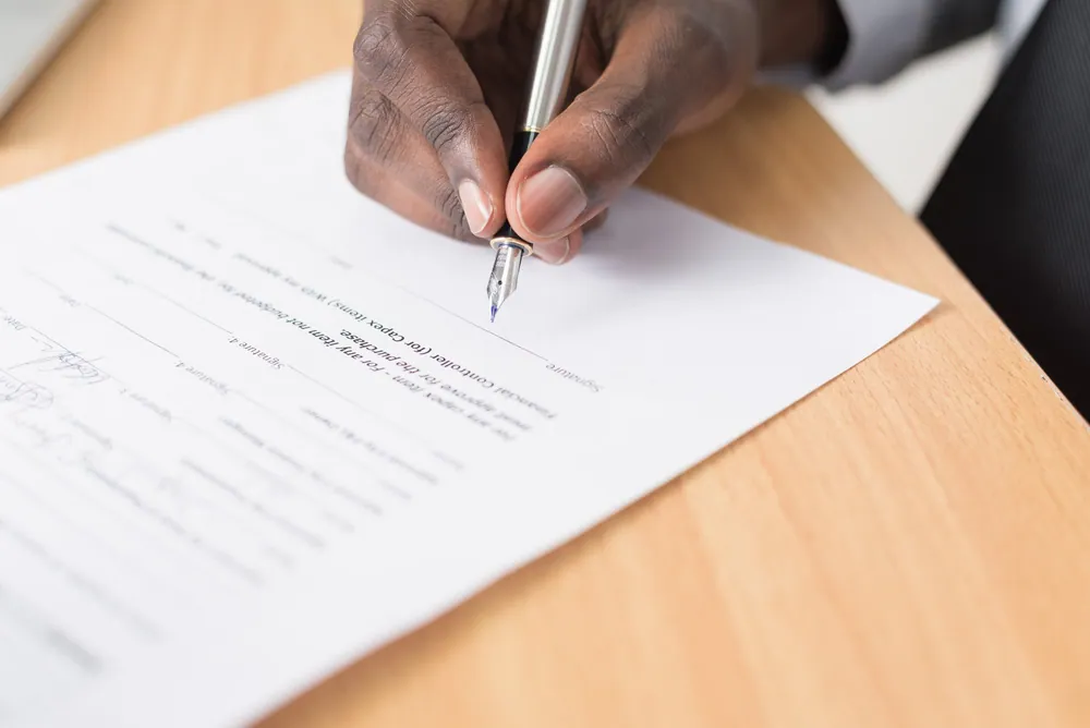 Une photo d'un homme signant un contrat à durée déterminée